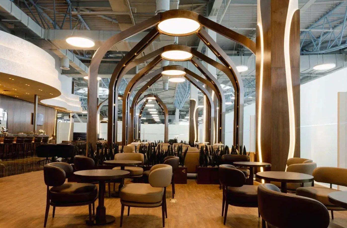 Air Astana Lounge at Almaty International Airport featuring elegant arched wooden frames, warm lighting, and comfortable seating for passengers.