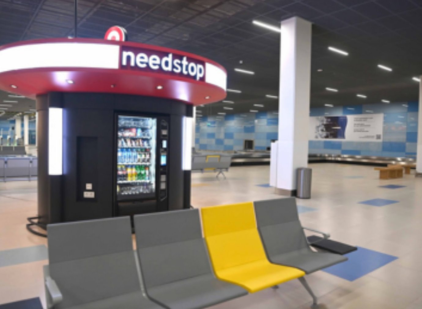 Baggage claim area at Almaty International Airport featuring the Needstop vending station and modern seating.