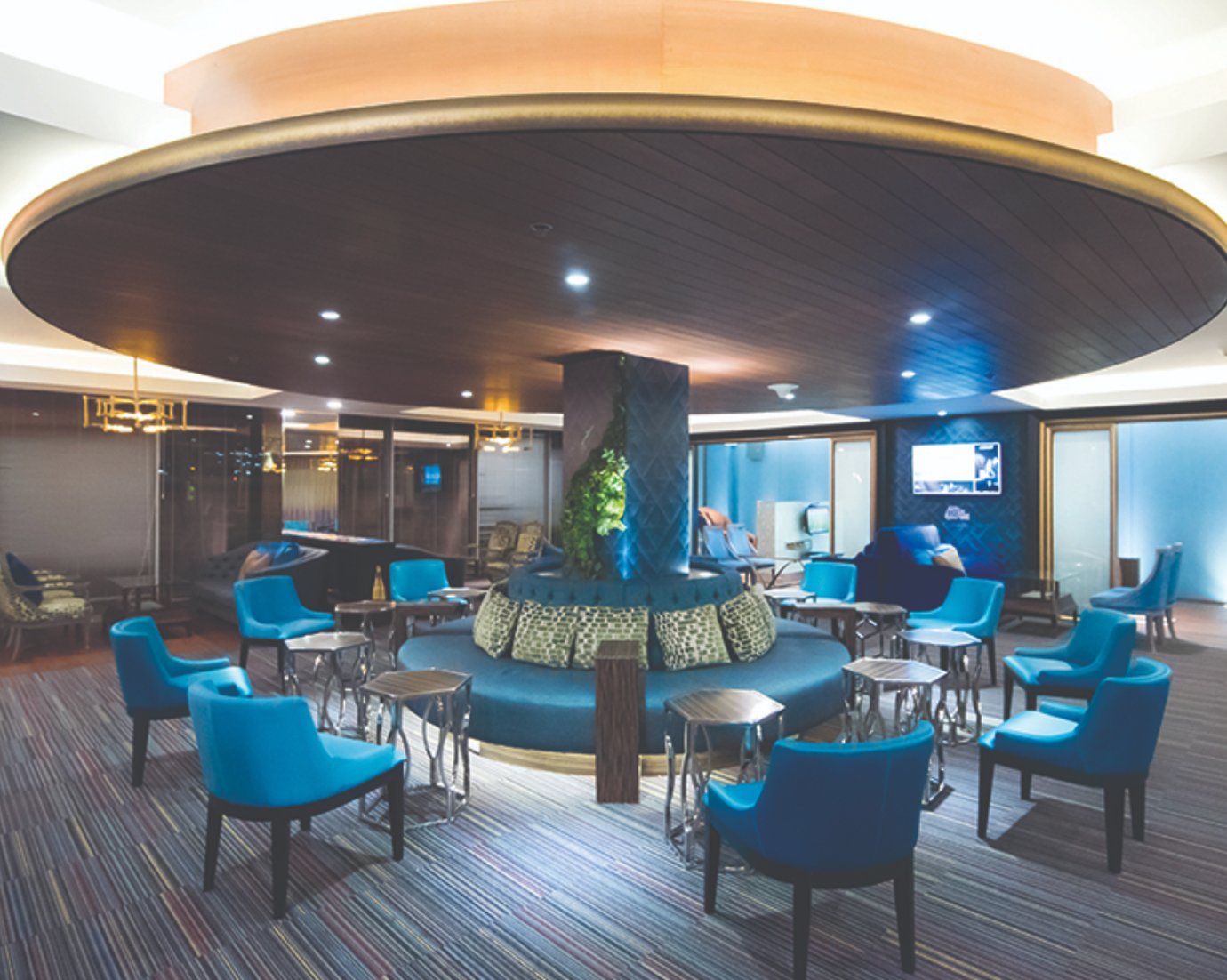 Bangkok Airways International Lounge at Suvarnabhumi Airport with blue seating, circular central seating area, and modern lighting design.