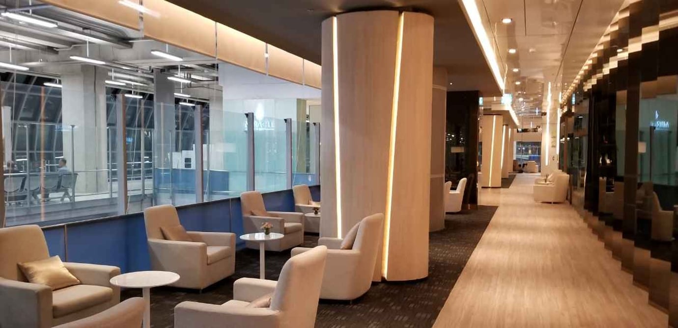 Comfortable seating zone inside the Miracle First Class Lounge Concourse D Bangkok Suvarnabhumi Airport with plush armchairs, small tables, warm ambient lighting, and modern décor.