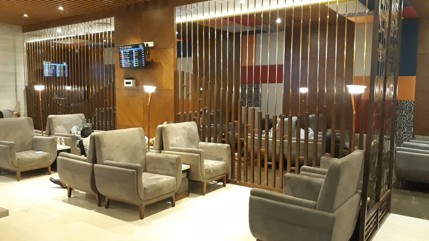 TFS Travel Club Lounge Chennai Terminal 1 seating area with plush grey armchairs and wooden privacy dividers.