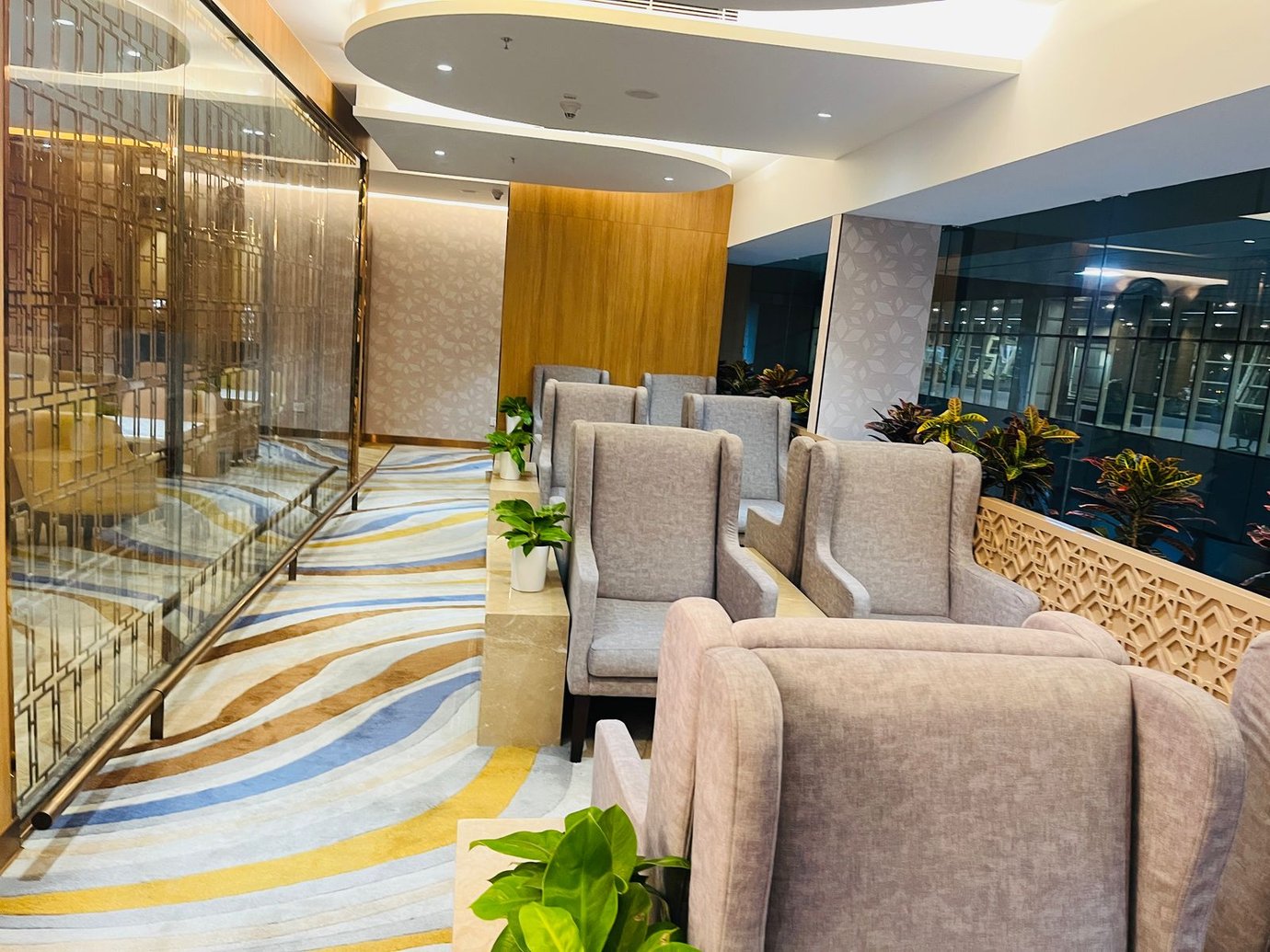 Comfortable armchair seating area at the Good Times Bar Lounge, Mumbai Airport T1, with modern decor and indoor plants. Comfortable armchair seating area at the Good Times Bar Lounge, Mumbai Airport T1, with modern decor and indoor plants.