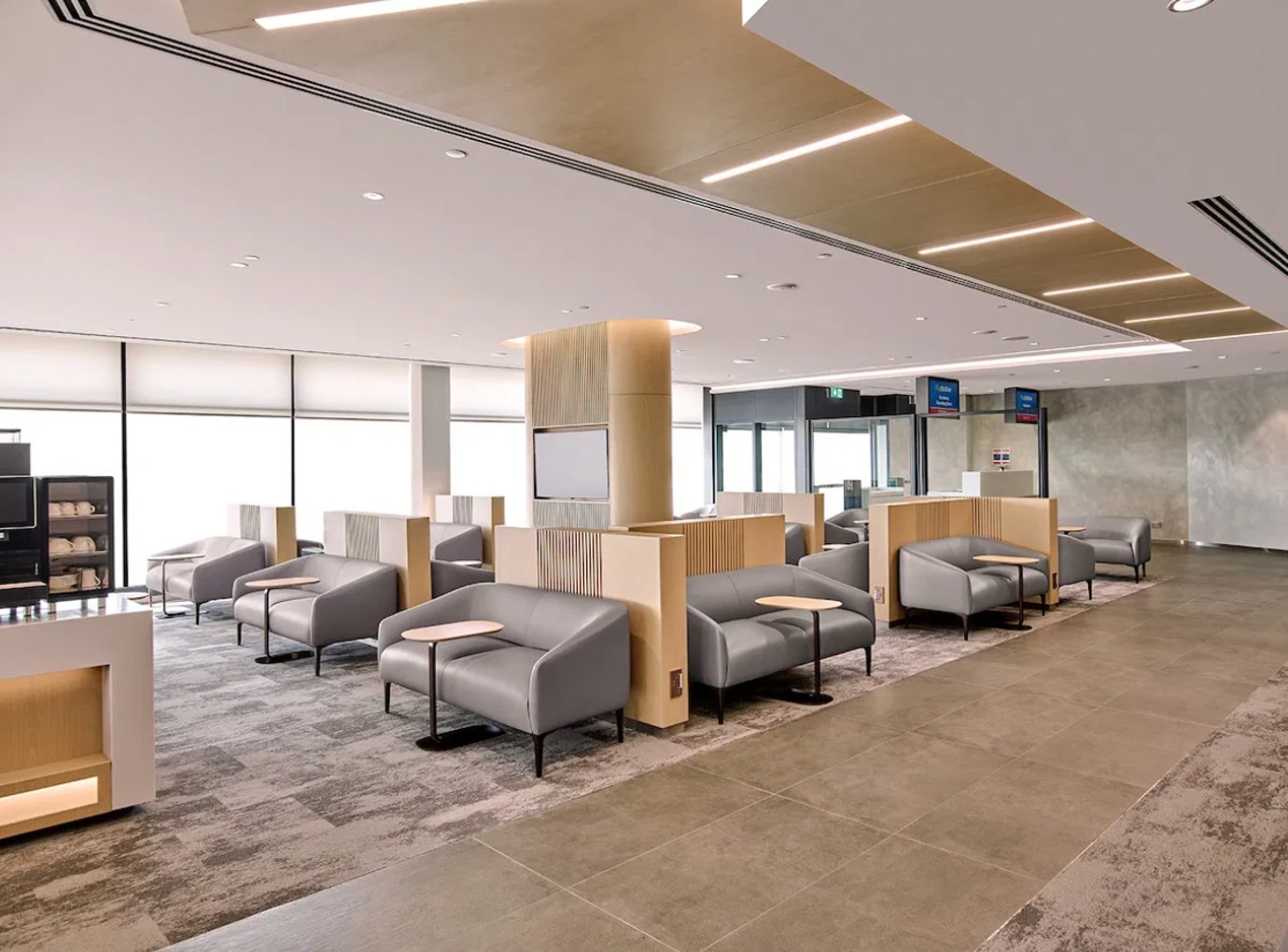 Flydubai Lounge in Dubai Airport Terminal 2 with grey armchairs, semi-private seating booths, and a bright, contemporary design ideal for passengers to relax before flights.