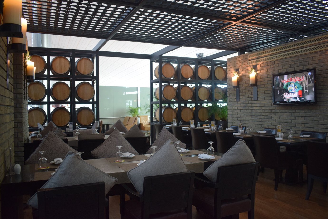 Dining area inside the Ahlan Lounge at Dubai International Airport Terminal 3 Concourse B, featuring elegant table settings, cushioned seating, warm lighting, and decorative wine barrel displays for a refined dining atmosphere. Dining area inside the Ahlan Lounge at Dubai International Airport Terminal 3 Concourse B, featuring elegant table settings, cushioned seating, warm lighting, and decorative wine barrel displays for a refined dining atmosphere.