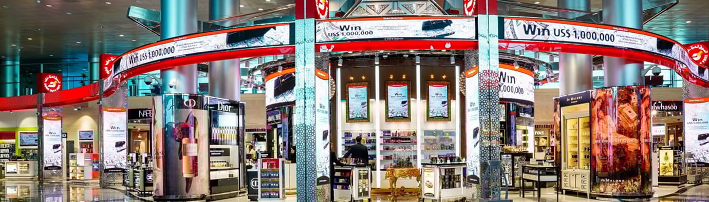 Dubai Duty Free store at Dubai Airport with luxury brands, illuminated signs, and travellers shopping for perfumes and gifts. Dubai Duty Free store at Dubai Airport with luxury brands, illuminated signs, and travellers shopping for perfumes and gifts.