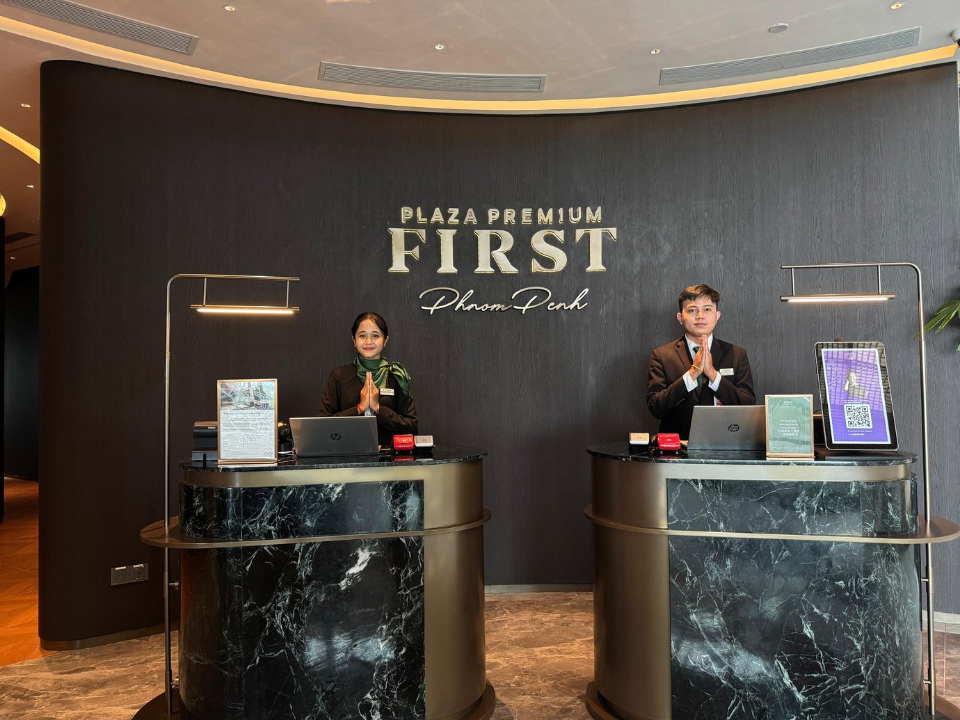 The reception area of Plaza Premium First at Techo International Airport features two service counters with staff ready to assist travelers. The reception area of Plaza Premium First at Techo International Airport features two service counters with staff ready to assist travelers.