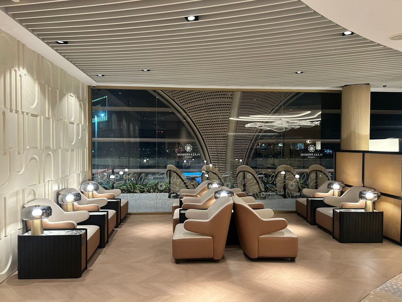 Seating area at Plaza Premium Lounge, Techo International Airport, features individual chairs with side tables and lamps, offering airport views. Seating area at Plaza Premium Lounge, Techo International Airport, features individual chairs with side tables and lamps, offering airport views.