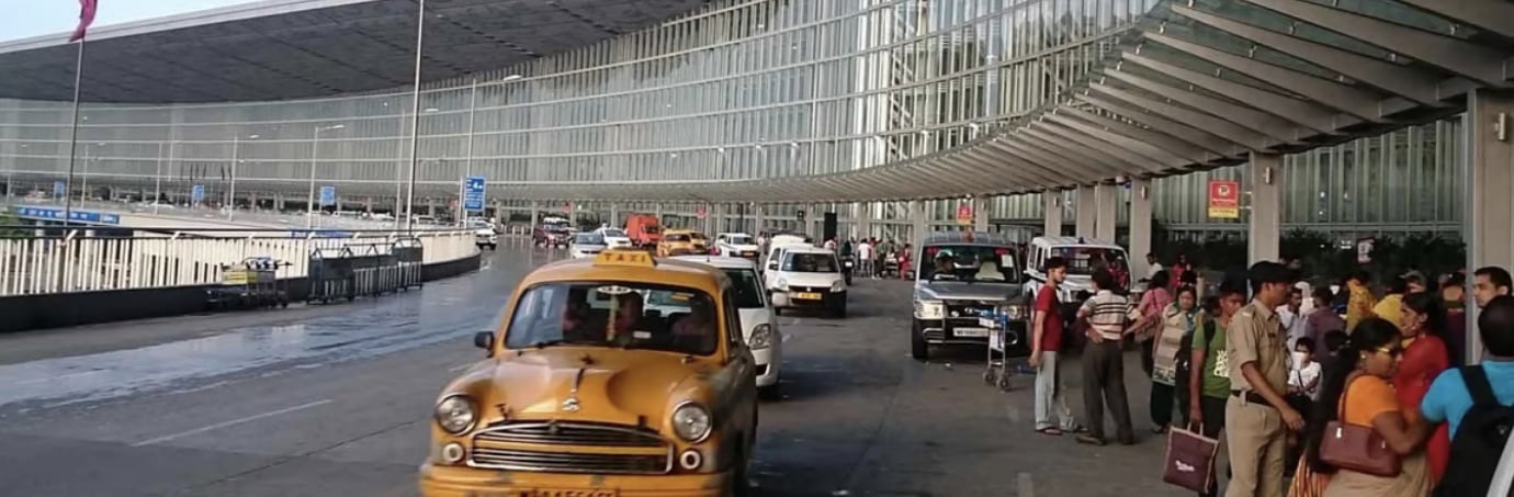 Exterior view of Kolkata Netaji Subhas Chandra Bose International Airport (CCU) with iconic yellow taxis at the departures drop-off. Exterior view of Kolkata Netaji Subhas Chandra Bose International Airport (CCU) with iconic yellow taxis at the departures drop-off.