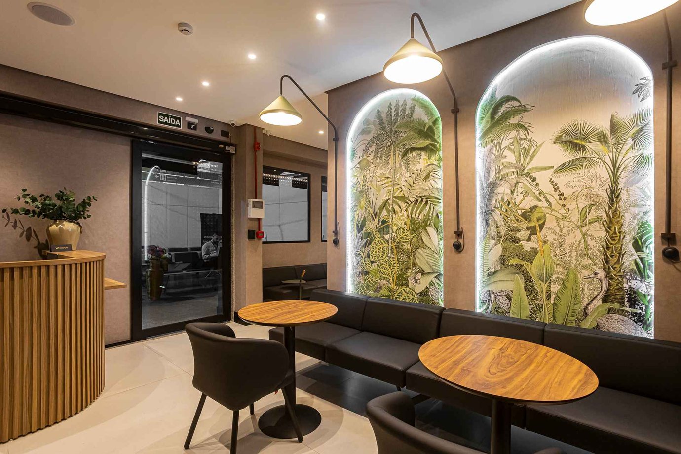 W Café Lounge seating area at Palmas–Brigadeiro Lysias Rodrigues Airport (PMW) with contemporary furniture, warm lighting, and large illuminated botanical murals. W Café Lounge seating area at Palmas–Brigadeiro Lysias Rodrigues Airport (PMW) with contemporary furniture, warm lighting, and large illuminated botanical murals.