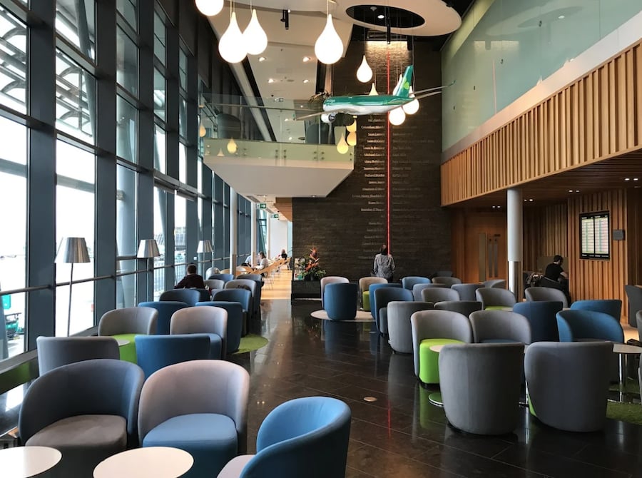 Bright and inviting Aer Lingus Lounge at Dublin Airport with comfortable blue seating and modern amenities.