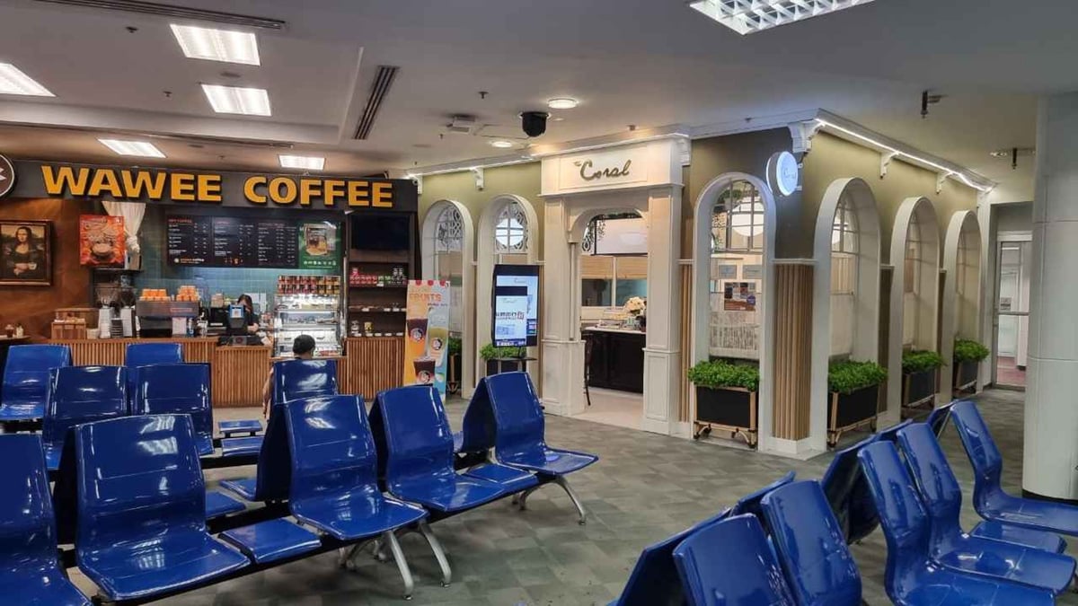 Entrance to The Coral Executive Lounge in the domestic terminal of Chiang Mai International Airport (CNX), located beside Wawee Coffee with blue airport seating in the foreground.