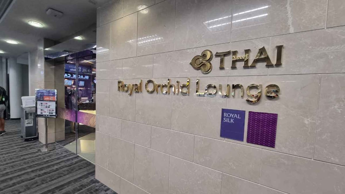 Entrance to the Thai Airways Royal Orchid Lounge (Royal Silk Lounge) at Chiang Mai International Airport (CNX), featuring polished beige marble walls with gold signage and glass doors leading into the reception area.