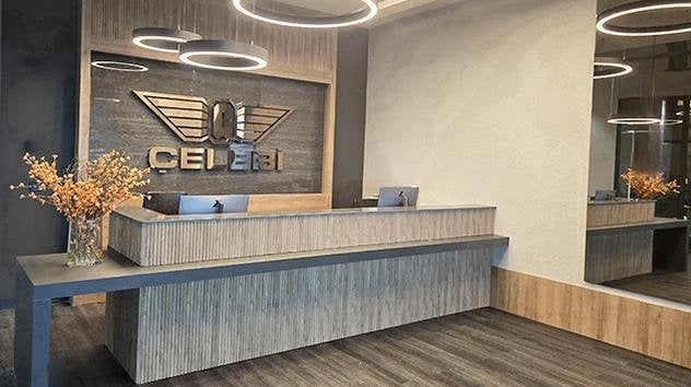 Modern reception area of the Çelebi Platinum Domestic Lounge at Çukurova International Airport, featuring sleek wood-panel design, LED ring lighting, and the Çelebi Aviation logo.