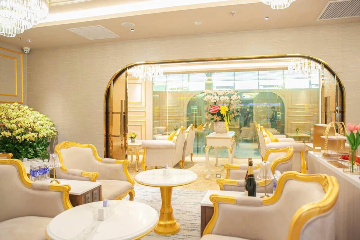 Elegant interior of Nam A Bank Premier Lounge at Da Nang Airport featuring gold-trimmed armchairs, marble tables, crystal chandeliers, and floral arrangements in a luxurious, neoclassical setting.