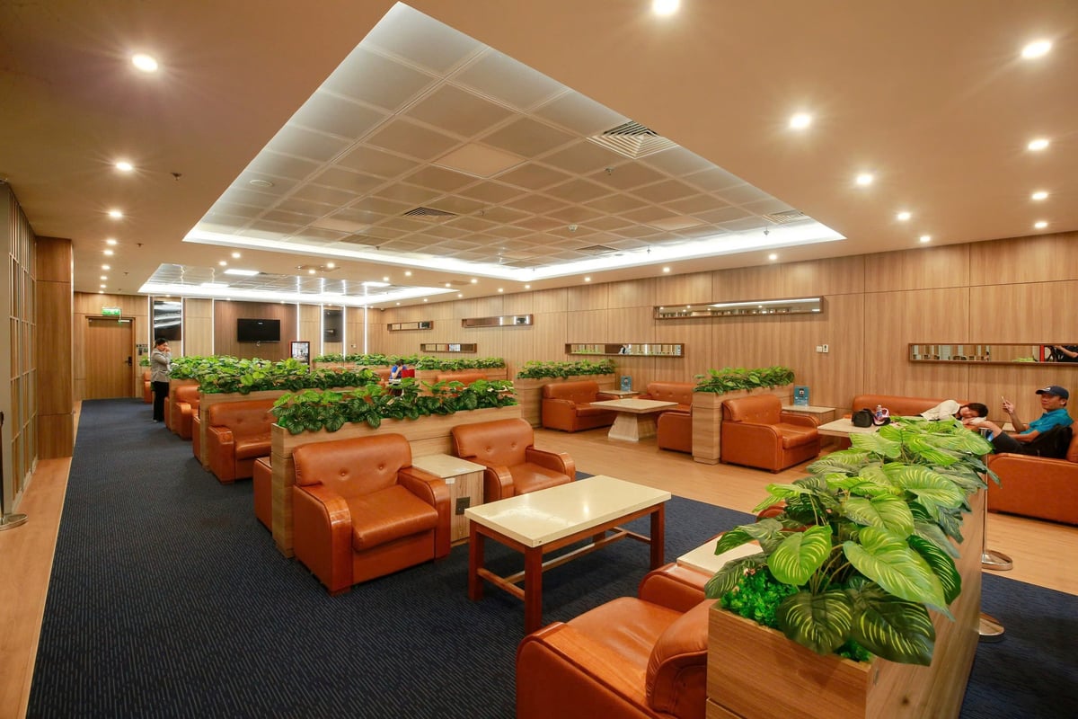 Vietnam Airlines Lotus Lounge at Da Nang International Airport featuring spacious seating with leather armchairs, wood-paneled walls, indoor greenery dividers, and a relaxed atmosphere for travelers.
