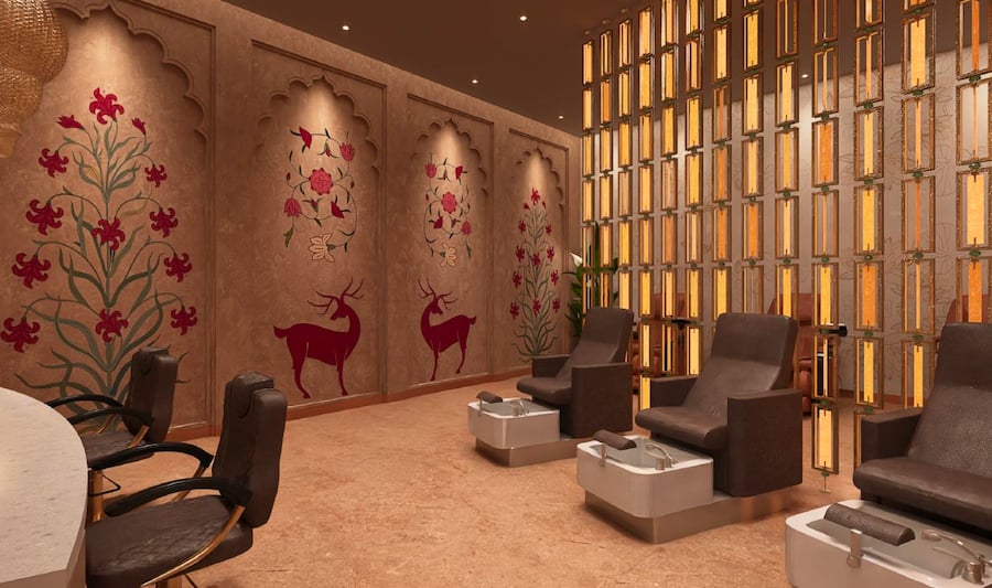Haveli spa at the t2 international 080 lounge at BLR airport. The space features elegant, brown reclining chairs with attached foot basins, arranged in a row for pedicure services.