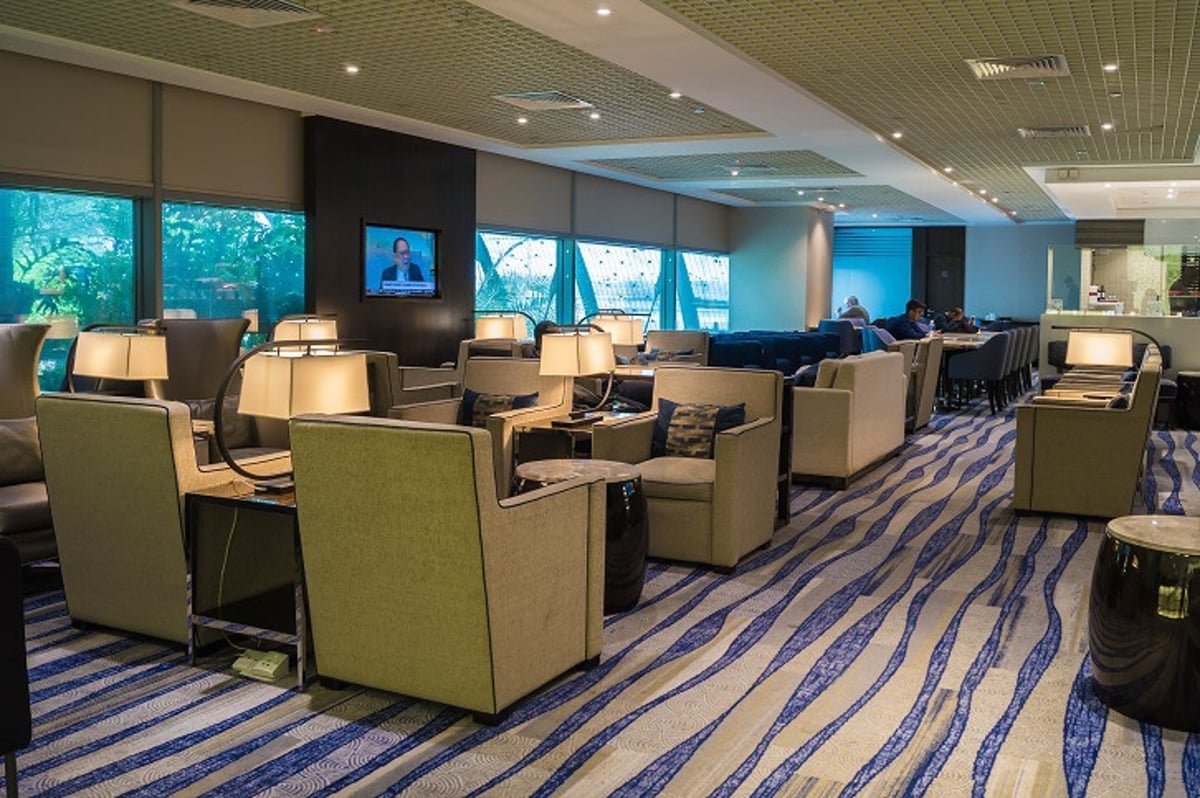Ambassador Transit Lounge at Singapore Changi Airport Terminal 3, featuring cushioned armchairs, ambient lighting, and a spacious seating area.