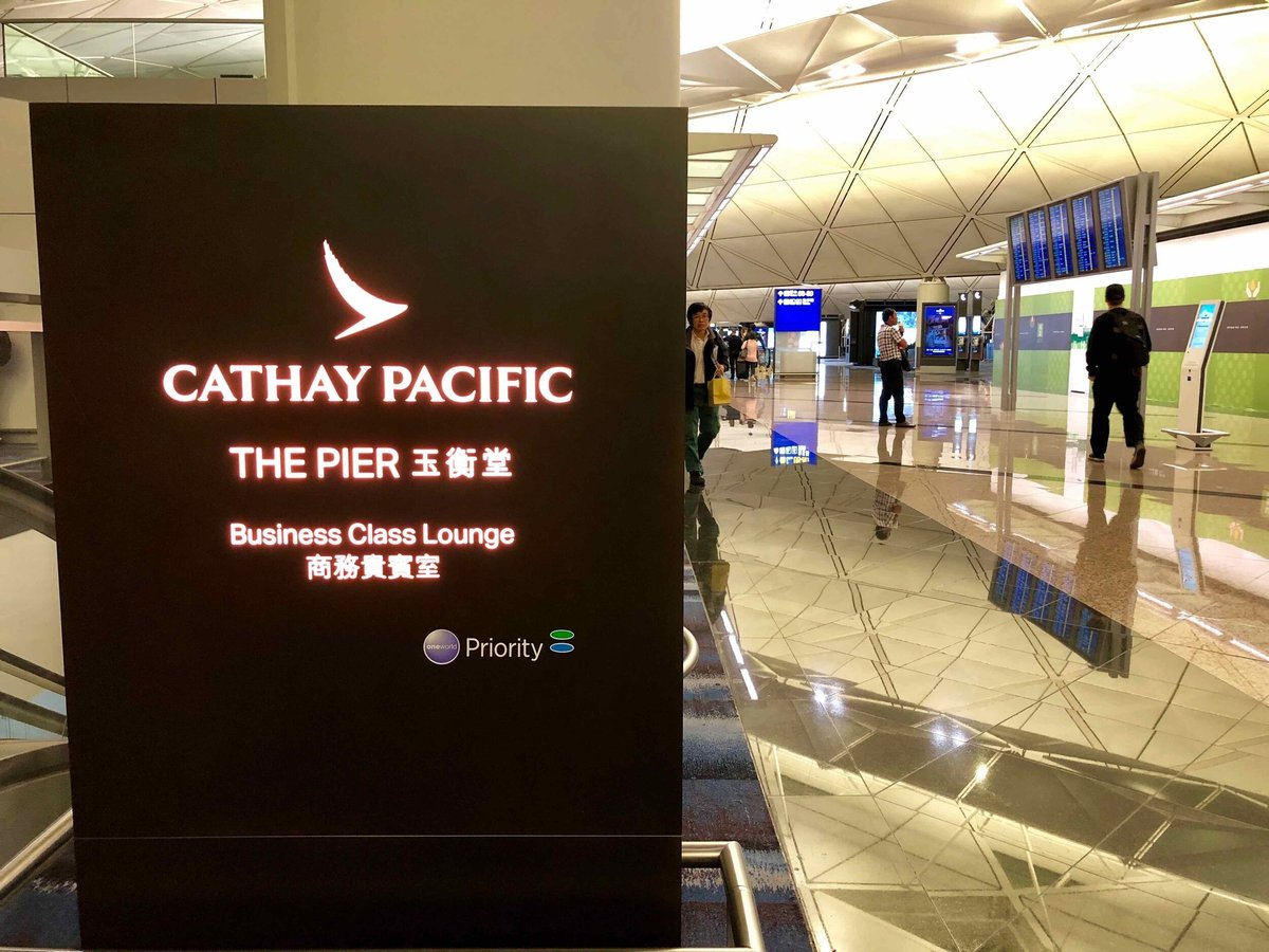 Entrance sign for Cathay Pacific's The Pier Business Class Lounge at Hong Kong International Airport featuring the sign in both Chinese and English languages.