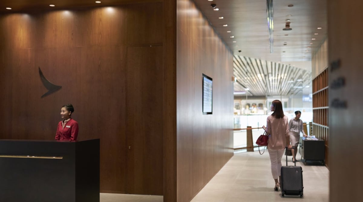 Entrance reception at Cathay Pacific Lounge Changi Airport Terminal 4 with staff welcoming passengers.