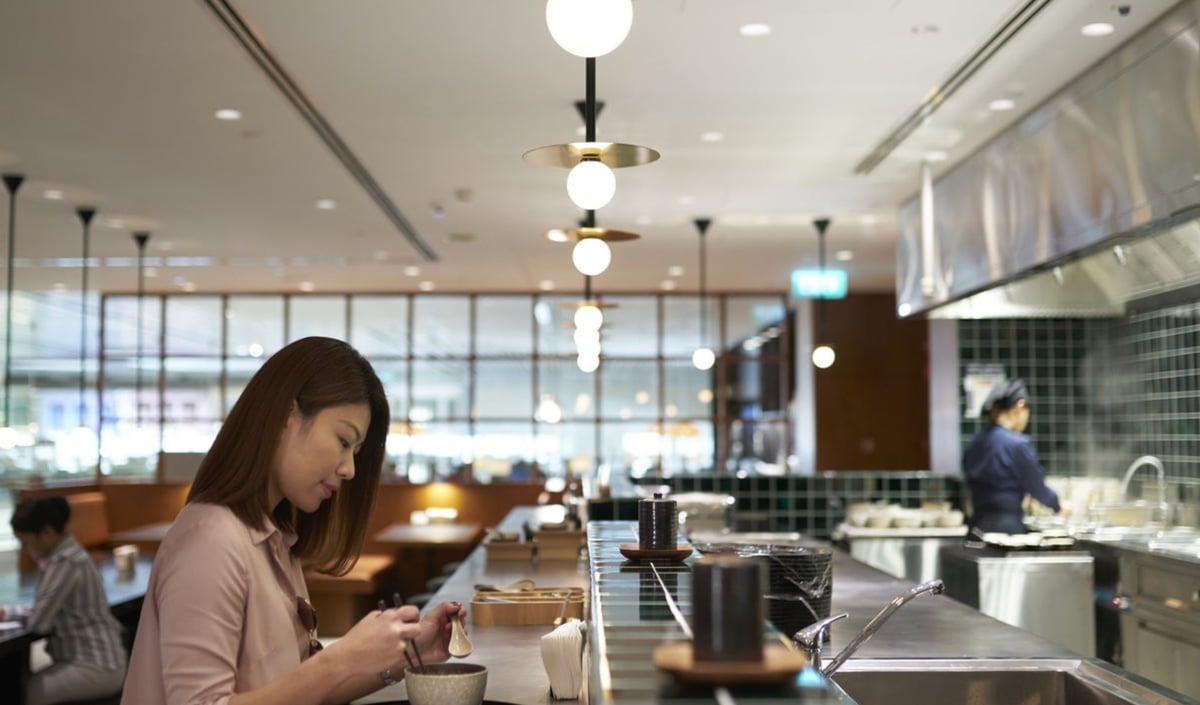 Passenger enjoying freshly prepared Asian cuisine at the dining bar inside Cathay Pacific Lounge, Changi Airport Terminal 4.
