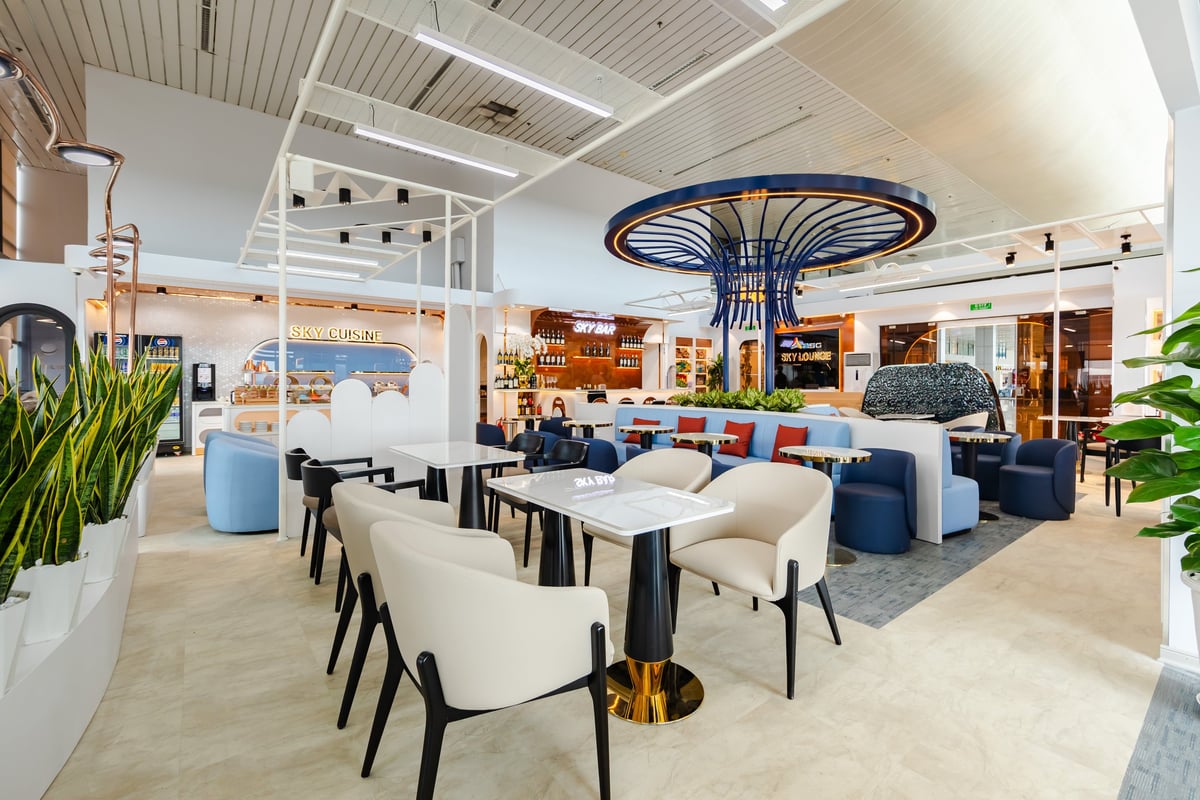 Interior of ASG Sky Lounge at Noi Bai Domestic Terminal, showcasing modern seating, Sky Bar, Sky Cuisine area, and stylish décor with a unique blue ceiling fixture.