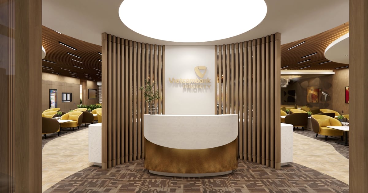 Entrance of the Vietcombank Priority Lounge at Hanoi Airport, showcasing a sleek white and gold reception desk with the Vietcombank Priority logo on a modern wooden slatted backdrop.
