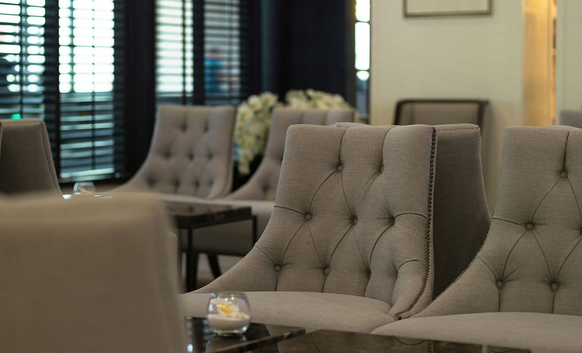 The Coral Premium Departure Lounge at Phuket Airport featuring luxurious chairs and elegant interior design.