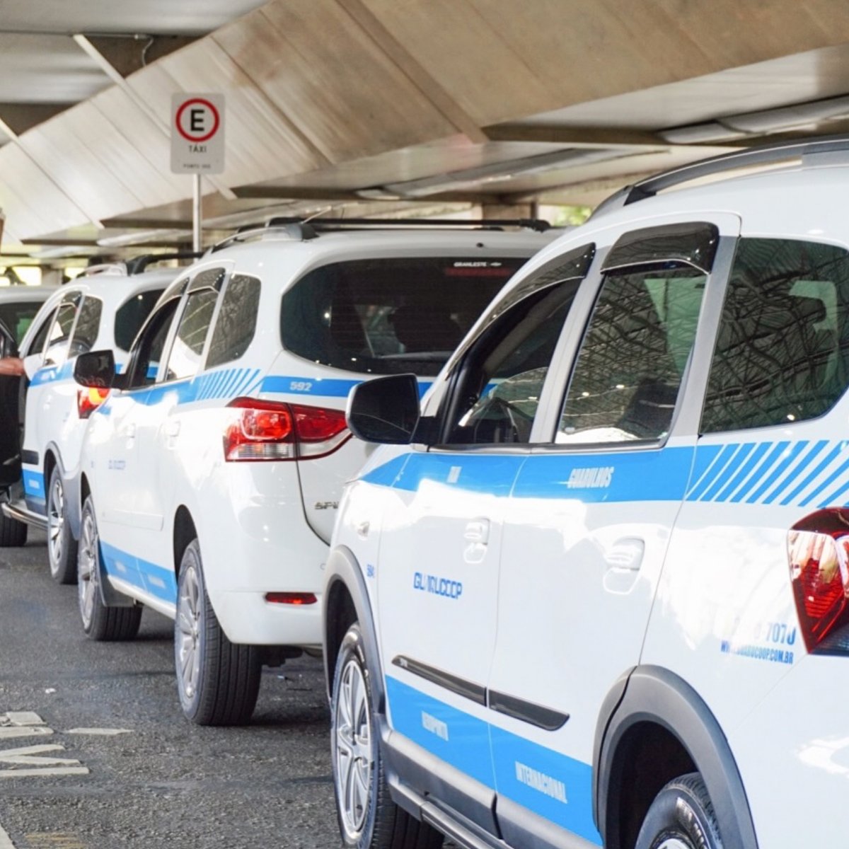 Line of Guarucoop airport taxis waiting at São Paulo Guarulhos International Airport terminal pickup area