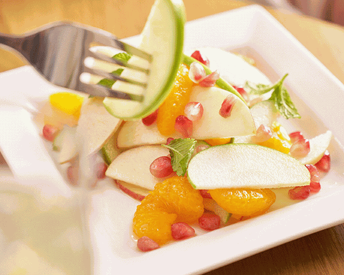 Fresh salad from the T3 escape lounge at PHX Airport, featuring a close up image of apples, mandarin and other salad items.