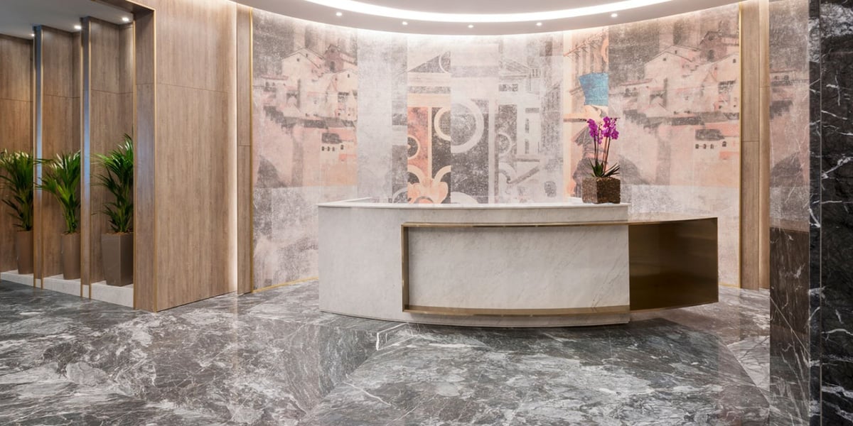 This image features the reception area of the Plaza Premium Lounge at Fiumicino Airport. The space is characterized by its luxurious and modern design, incorporating high-quality materials and artistic elements.