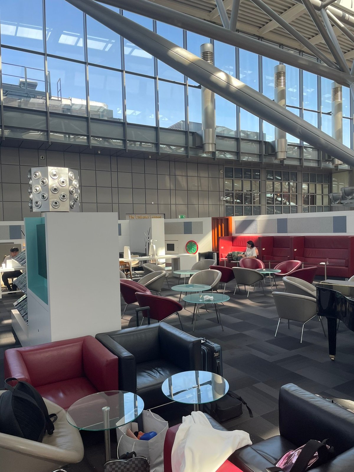 This image shows Hamburg airport lounge, a spacious and modern area featuring comfortable leather chairs and small glass tables.