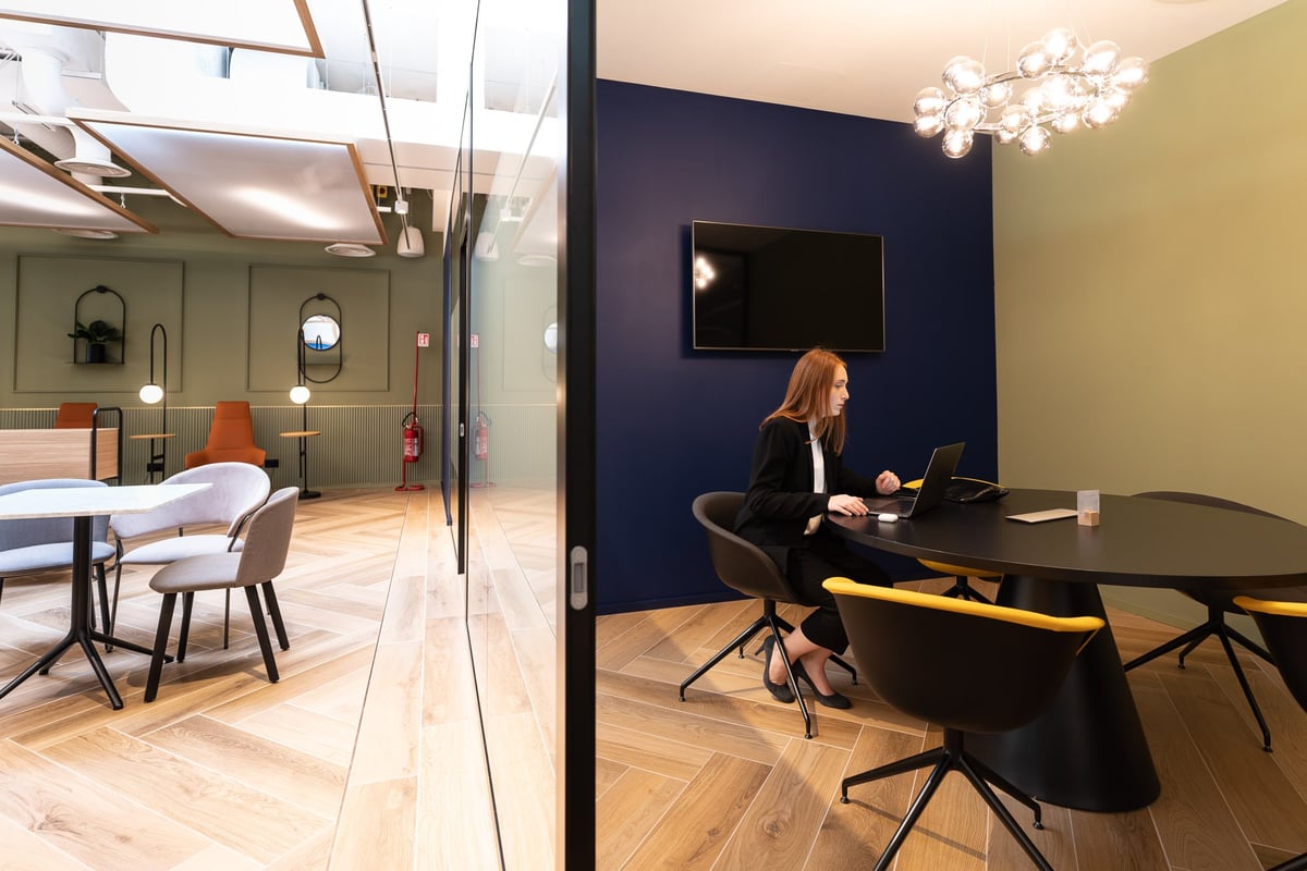 Woman working within a for-hire meeting room spaces at Milan HelloSky Lounge