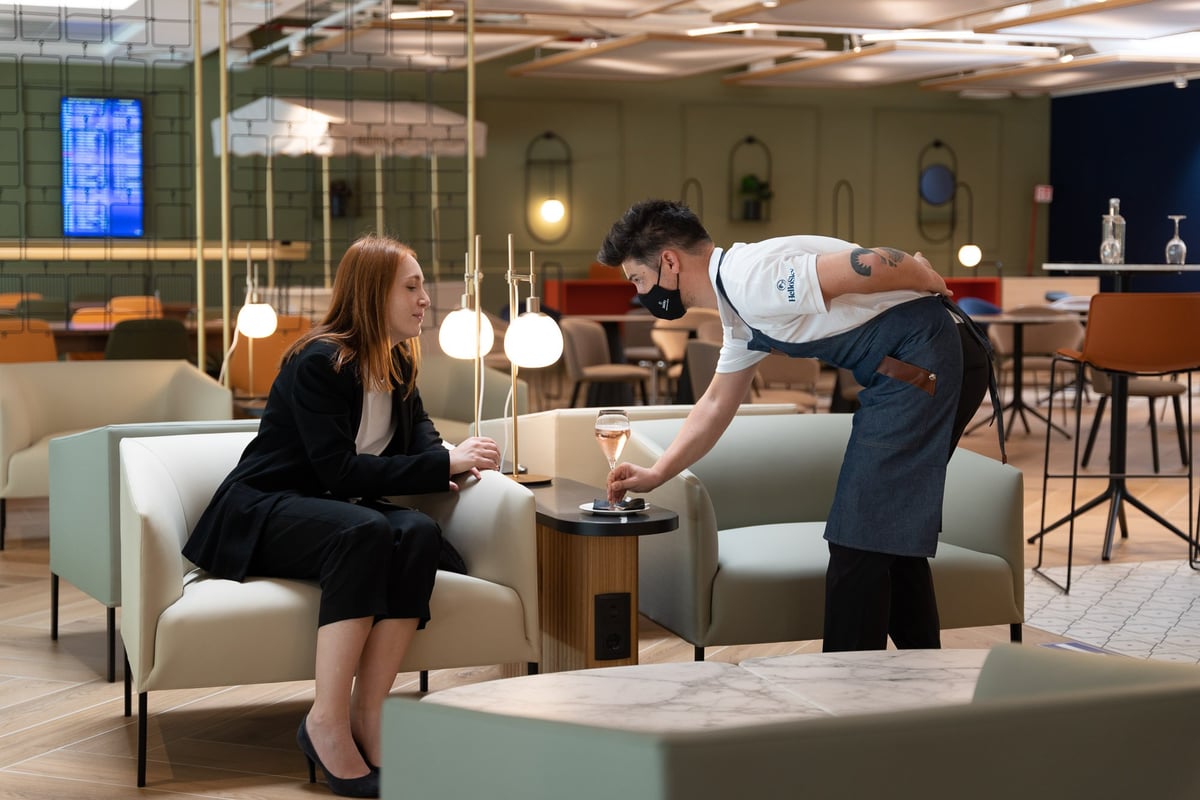 Man serving a drink to a woman at Milan HelloSky Lounge