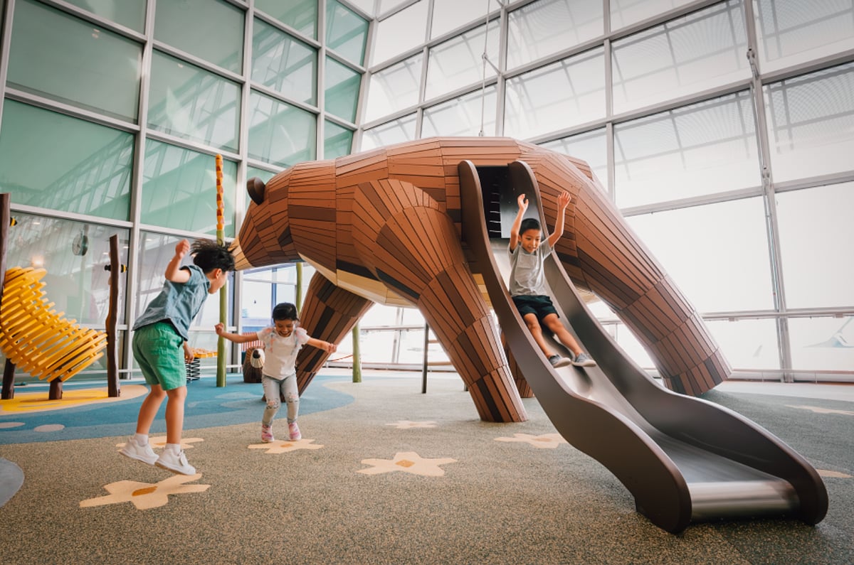 Indoor playground at Terminal 2 Singapore Changi Airport featuring children using a slide and jumping.