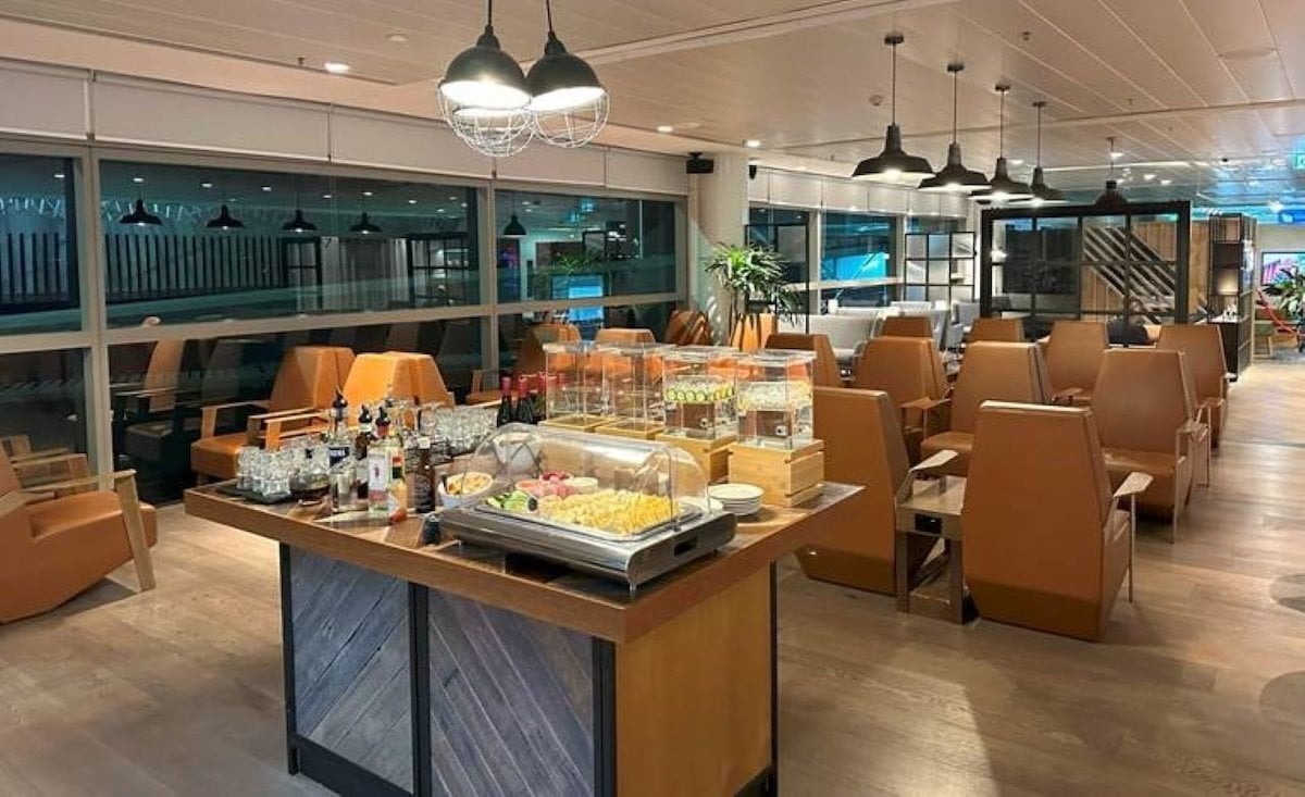 Open buffet area at the plaza premium lounge at Brisbane airport, featuring an assortment of salads and beverages including wine. In the background is a variety of neutral coloured seating options.