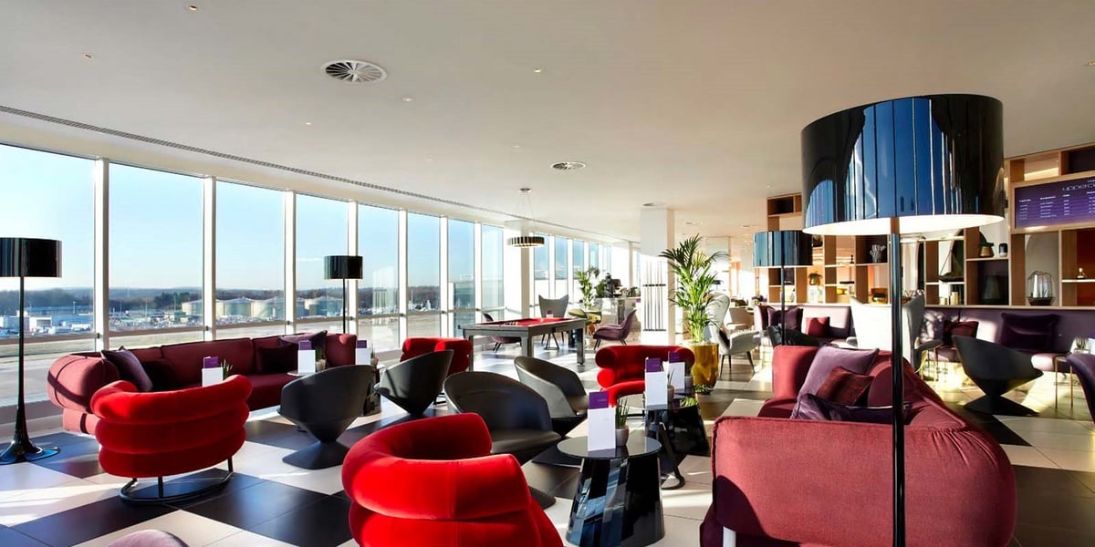 Panoramic view of seating and large floor to floor windows through the Plaza Premium Lounge Gatwick