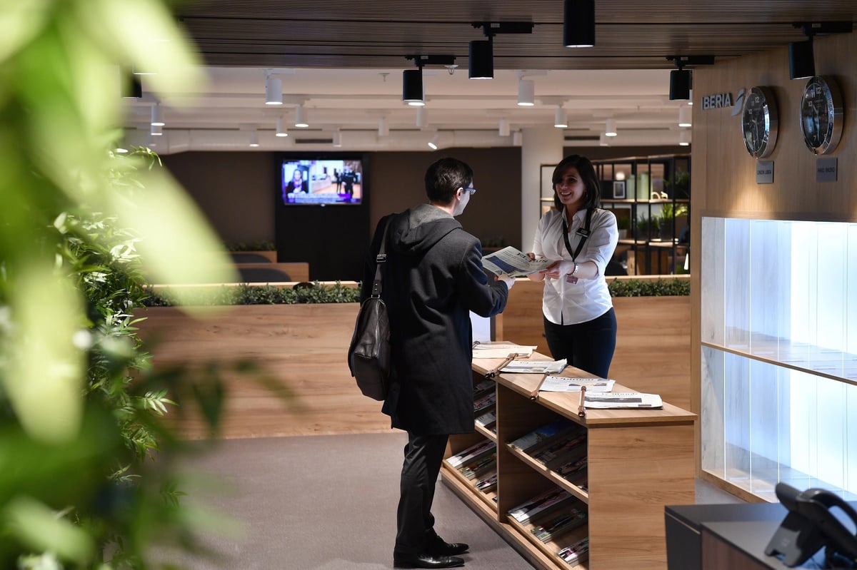 Welcoming reception desk at Premium Traveller Lounge in Orly Airport with staff assisting a traveler.