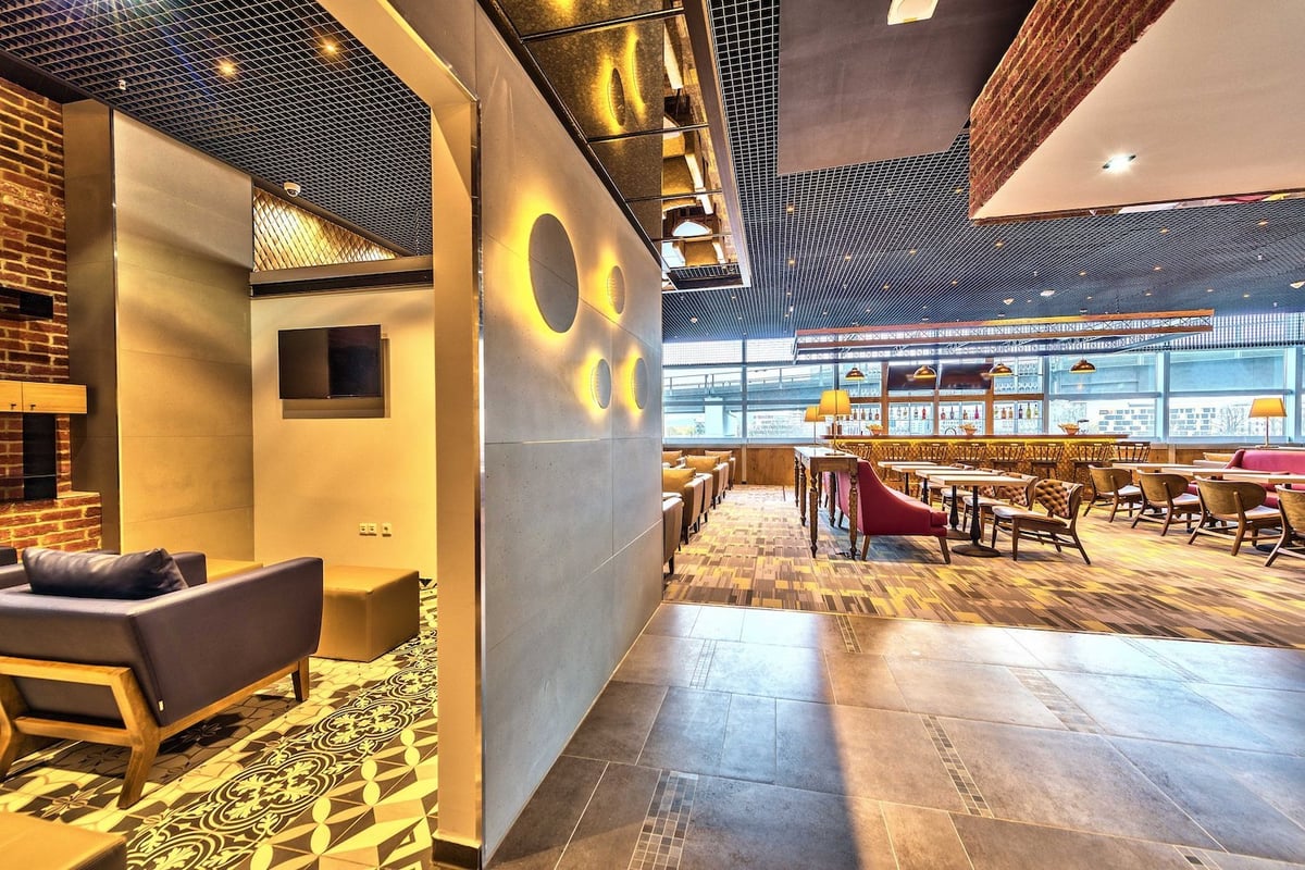 Elegant Primeclass Lounge at Frankfurt Airport with modern seating, TVs, and a vibrant bar area.
