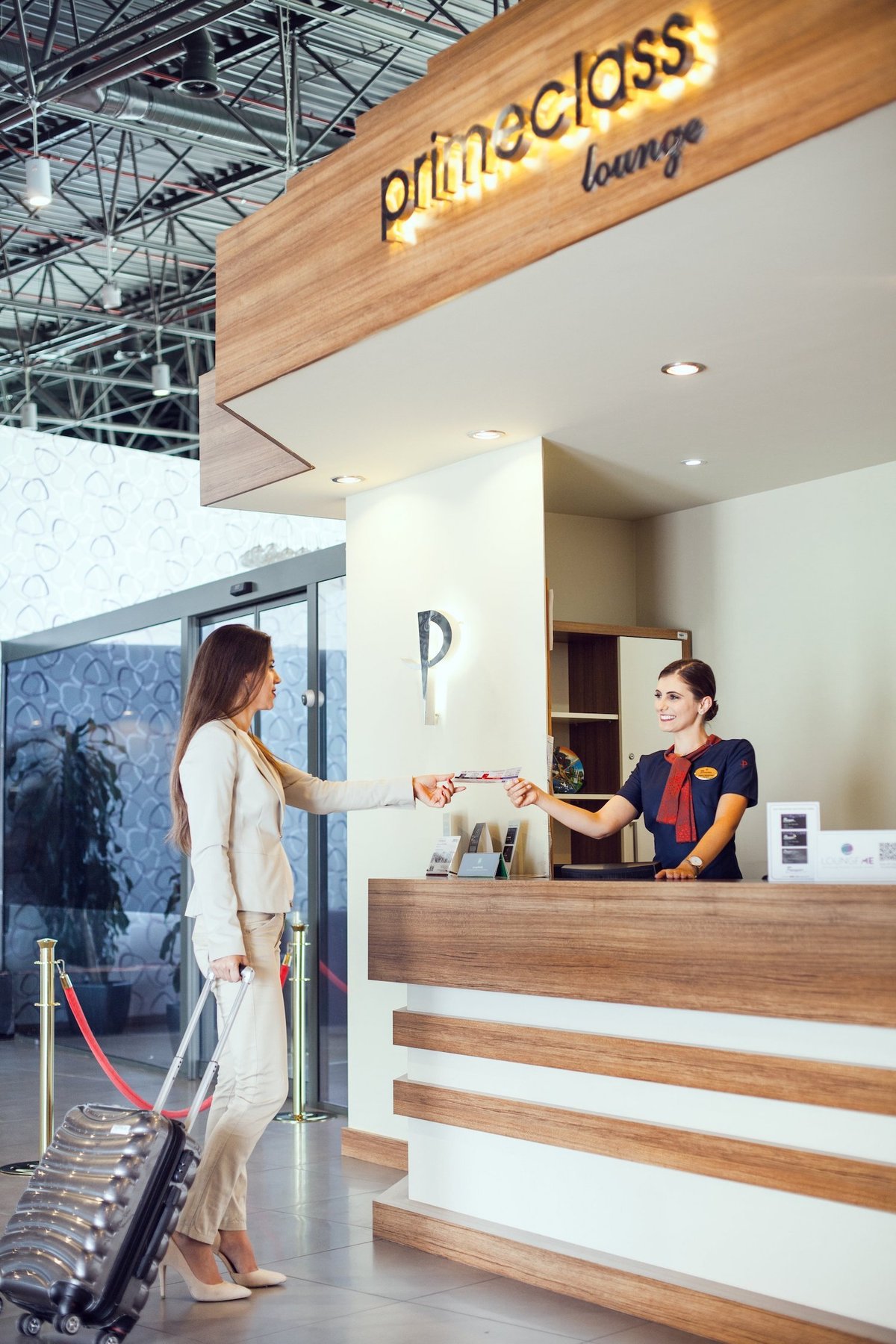 Entry desk and woman handing over boarding pass to Primeclass Lounge at Skopje Airpirt