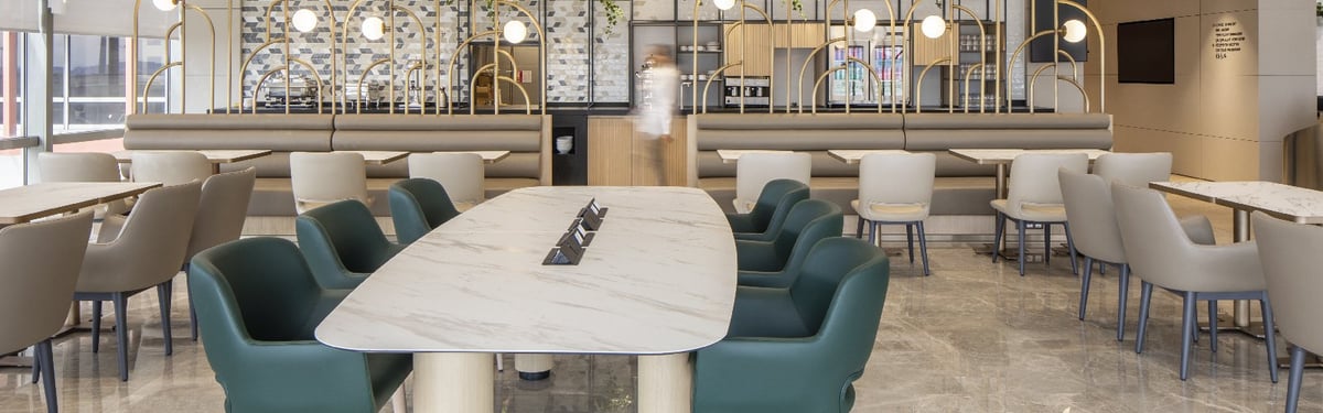 Lounge seating area with communal tables, arched metallic wall designs.
