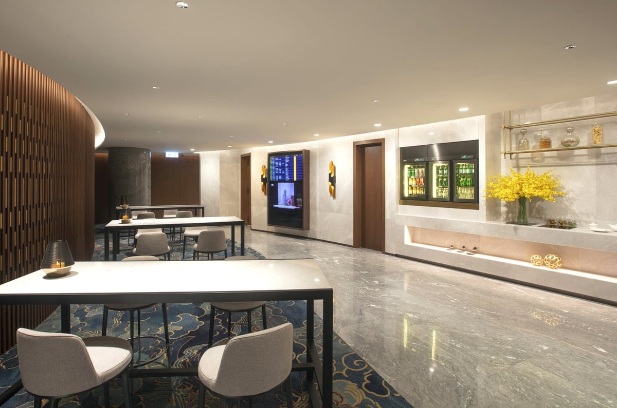 Elegant Cantonese dim sum and traditional Chinese tea set served at HKIA VIP Lounge, featuring steamed dumplings, baked buns, and porcelain teapots in a refined luxury setting.