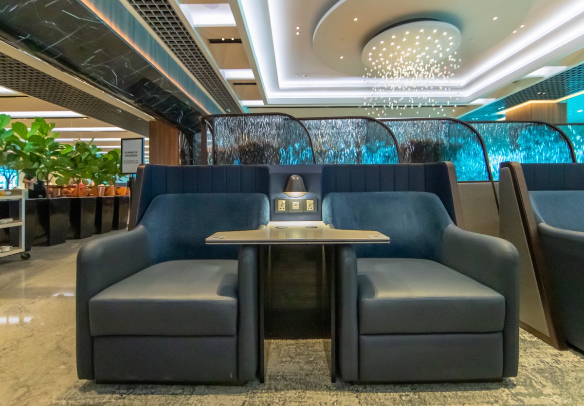 Comfortable seating with power outlets at the SilverKris Business Class Lounge in Singapore Changi Airport, featuring modern design and soft lighting.