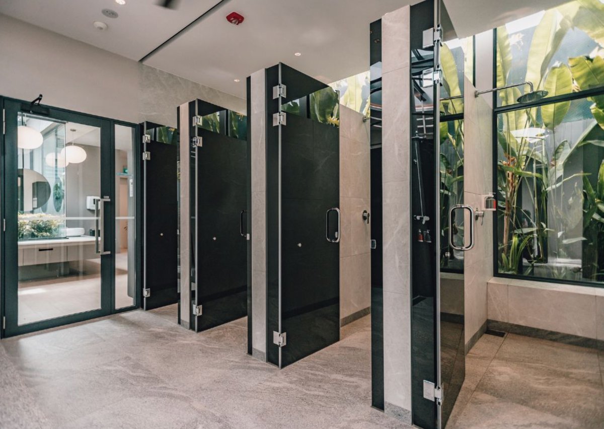 Modern shower facilities at Changi Airport with private cubicles, sleek design, and natural light for traveler comfort.