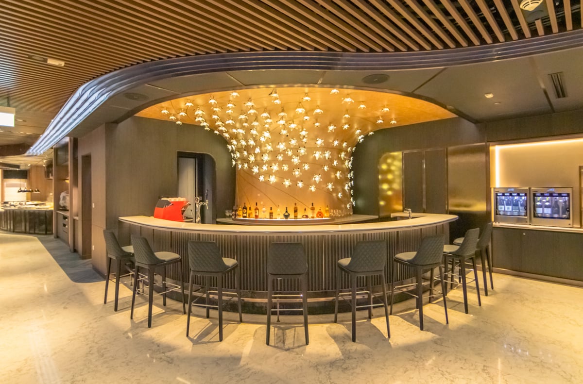 Elegant bar area in the SilverKris First Class Lounge at Singapore Changi Airport, featuring modern seating, backlit decor, and premium drink selection.