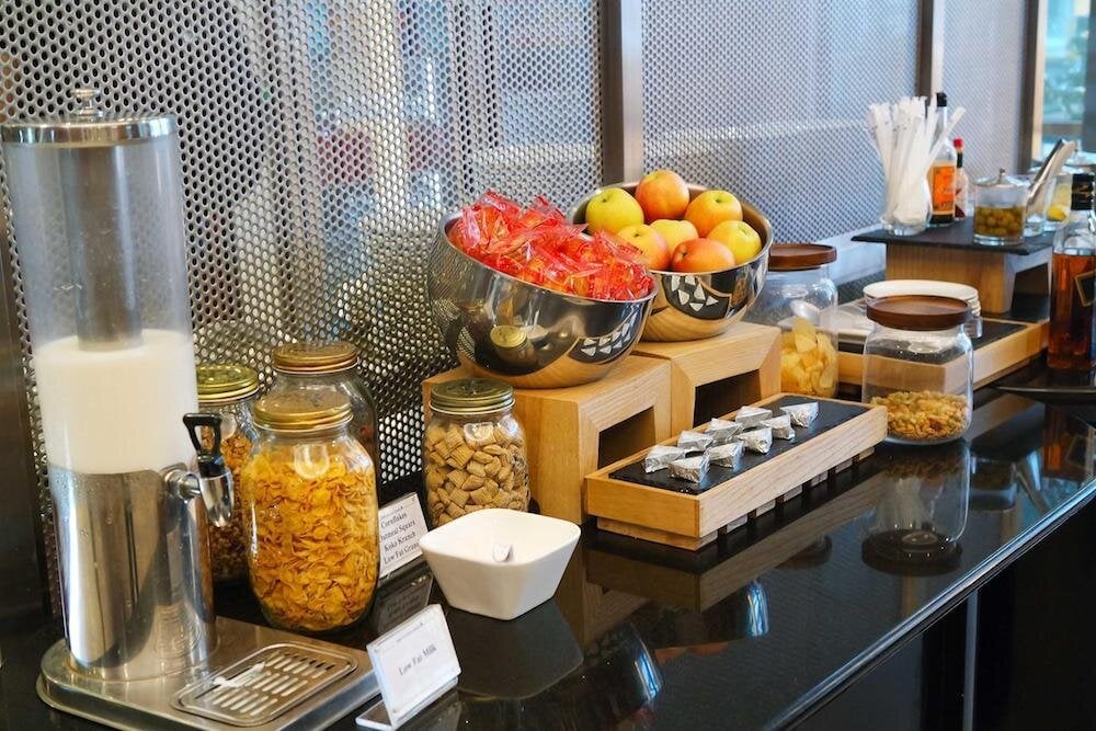 Snack and breakfast counter at KrisFlyer Gold Lounge in Singapore Changi Airport Terminal 3, offering cereal, fresh fruit, and packaged treats.