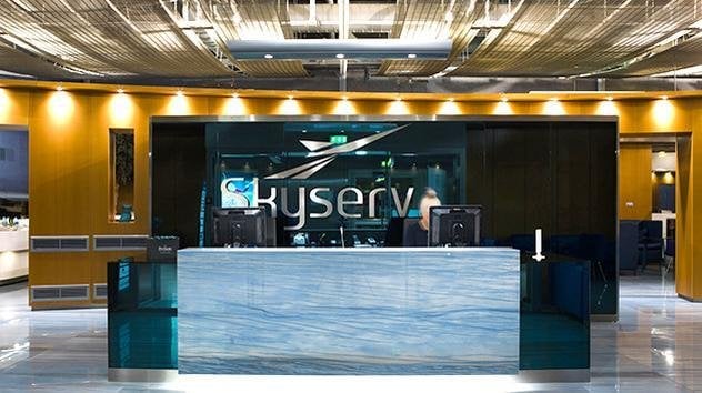 Skyserv Melina Mercouri Lounge reception desk, featuring the skyserv logo behind a light blue desk.