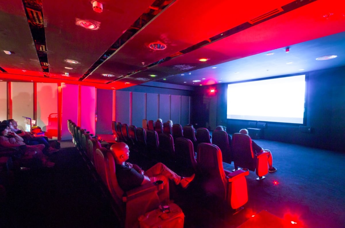 Passengers watching a movie at the free cinema theatre in Singapore Changi Airport Terminal 3, offering entertainment during layovers.