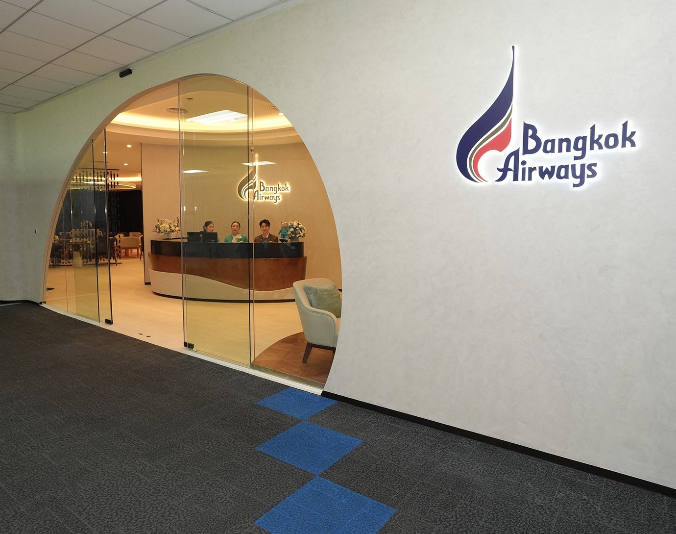 Bangkok Airways lounge entrance at airport with reception desk and modern interior.