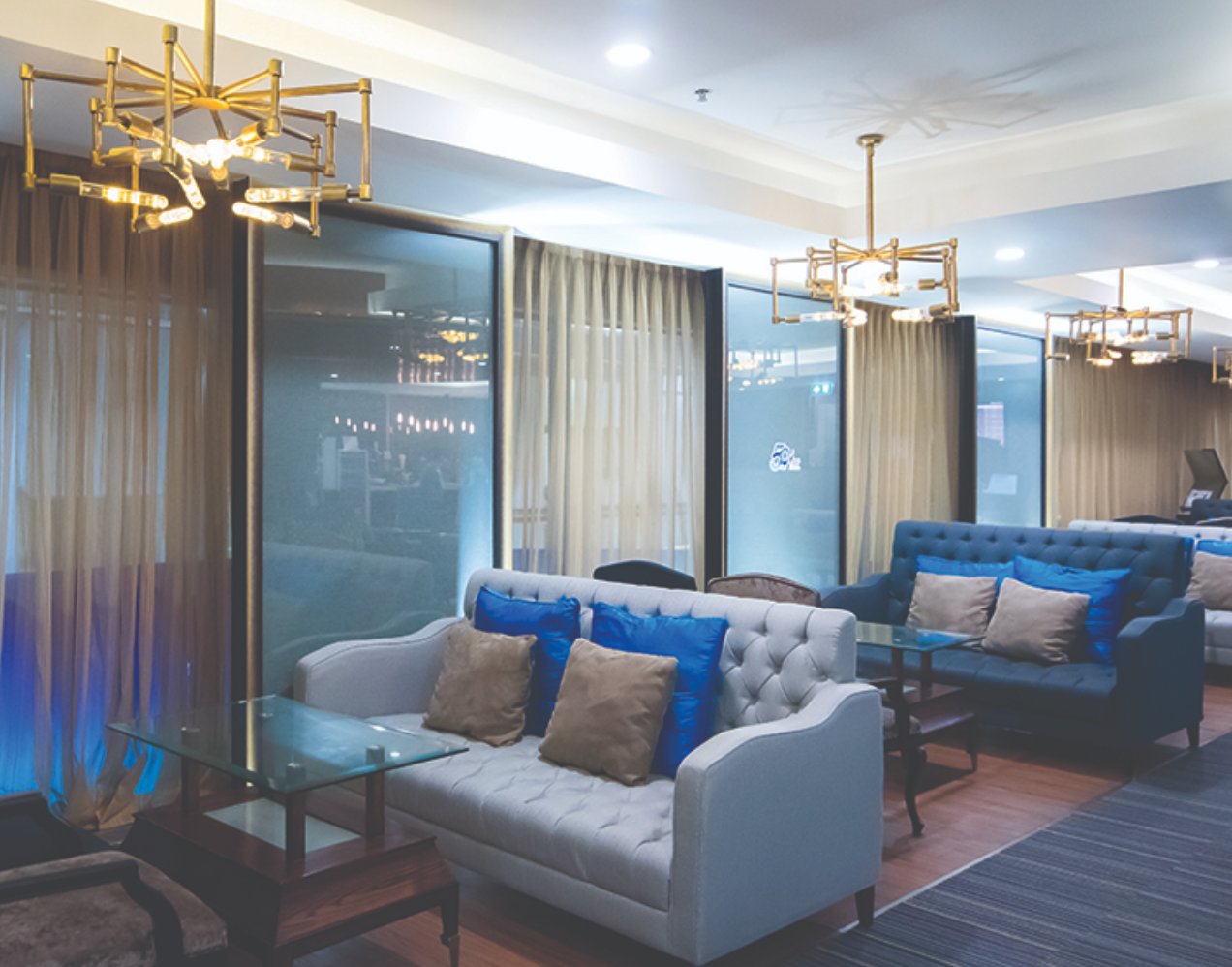 Bangkok Airways Domestic Lounge at Suvarnabhumi Airport featuring tufted sofas, warm lighting, and an intimate seating area with glass partitions. Bangkok Airways Domestic Lounge at Suvarnabhumi Airport featuring tufted sofas, warm lighting, and an intimate seating area with glass partitions.