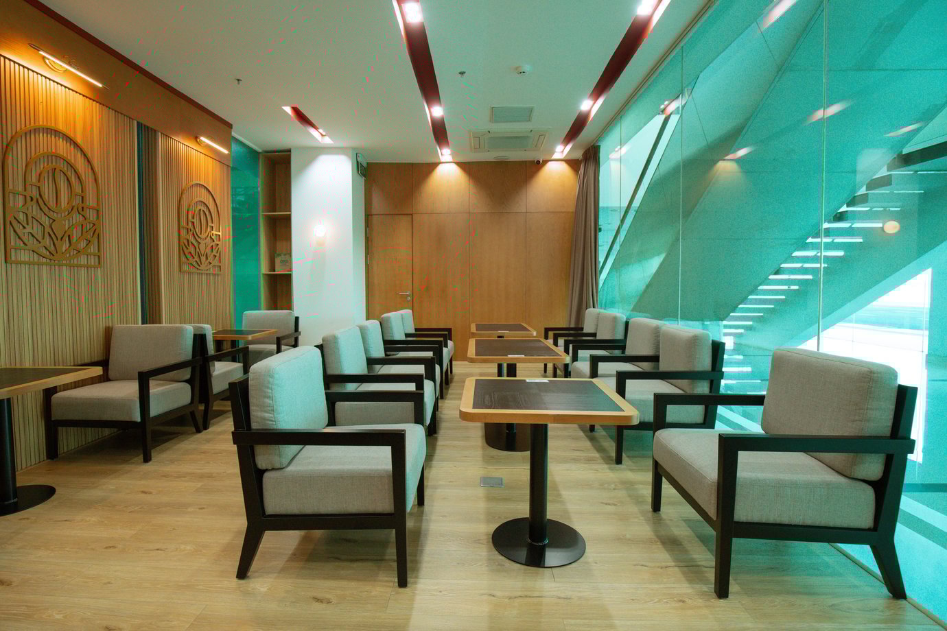SH Premium Lounge Buon Ma Thuot Airport (BMV) seating area with modern armchairs, café tables, and floor-to-ceiling glass